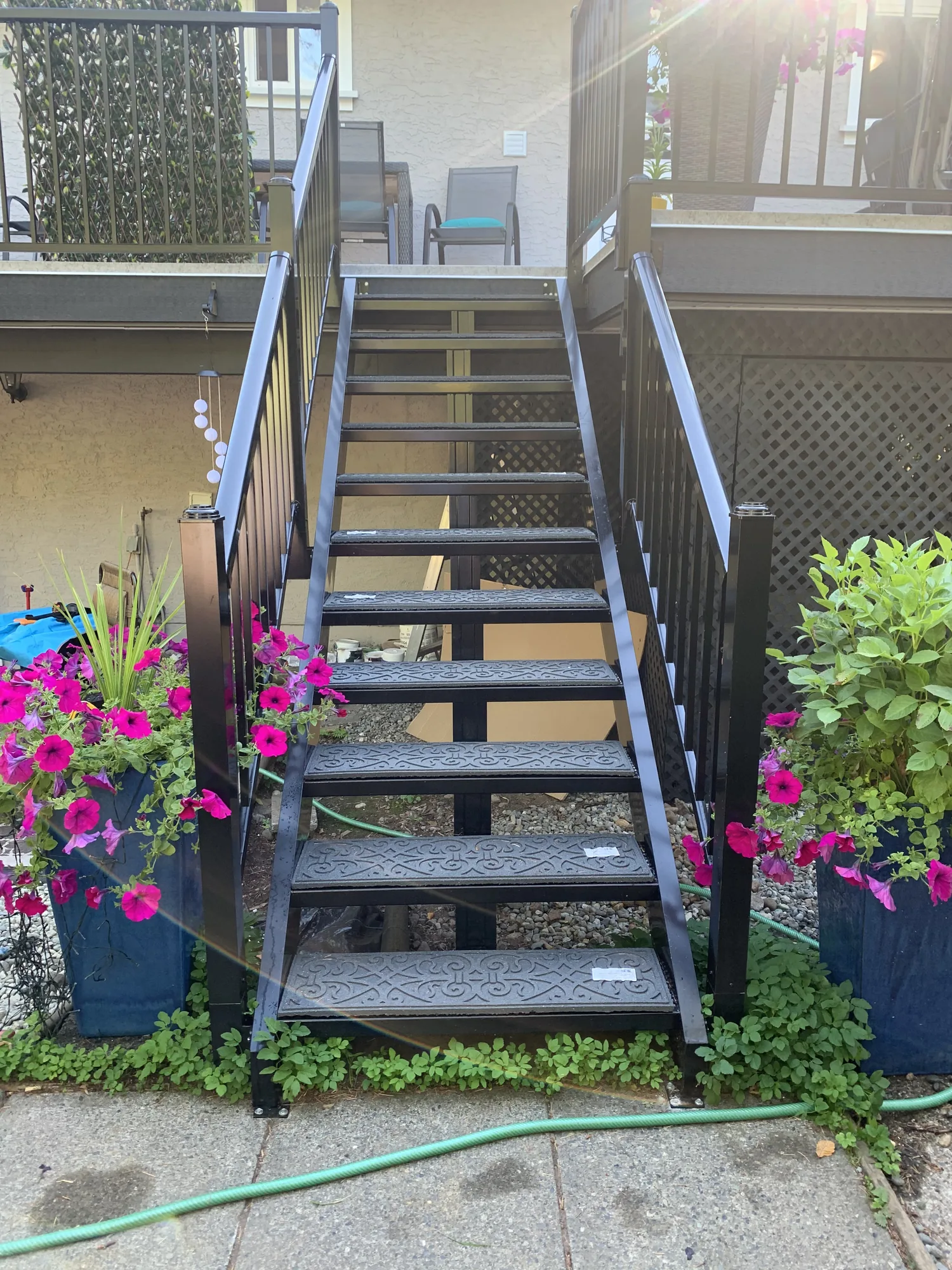 Exterior stairs with black railings and planters